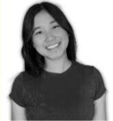 Ivi, an Asian woman with black hair & dark eyes is smiling. The photo is in greyscale.